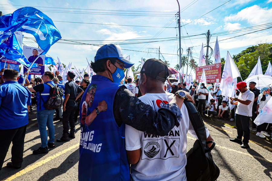 尽管所支持的阵营不同，但两名支持者仍互相为对方的候选人加油打气。
