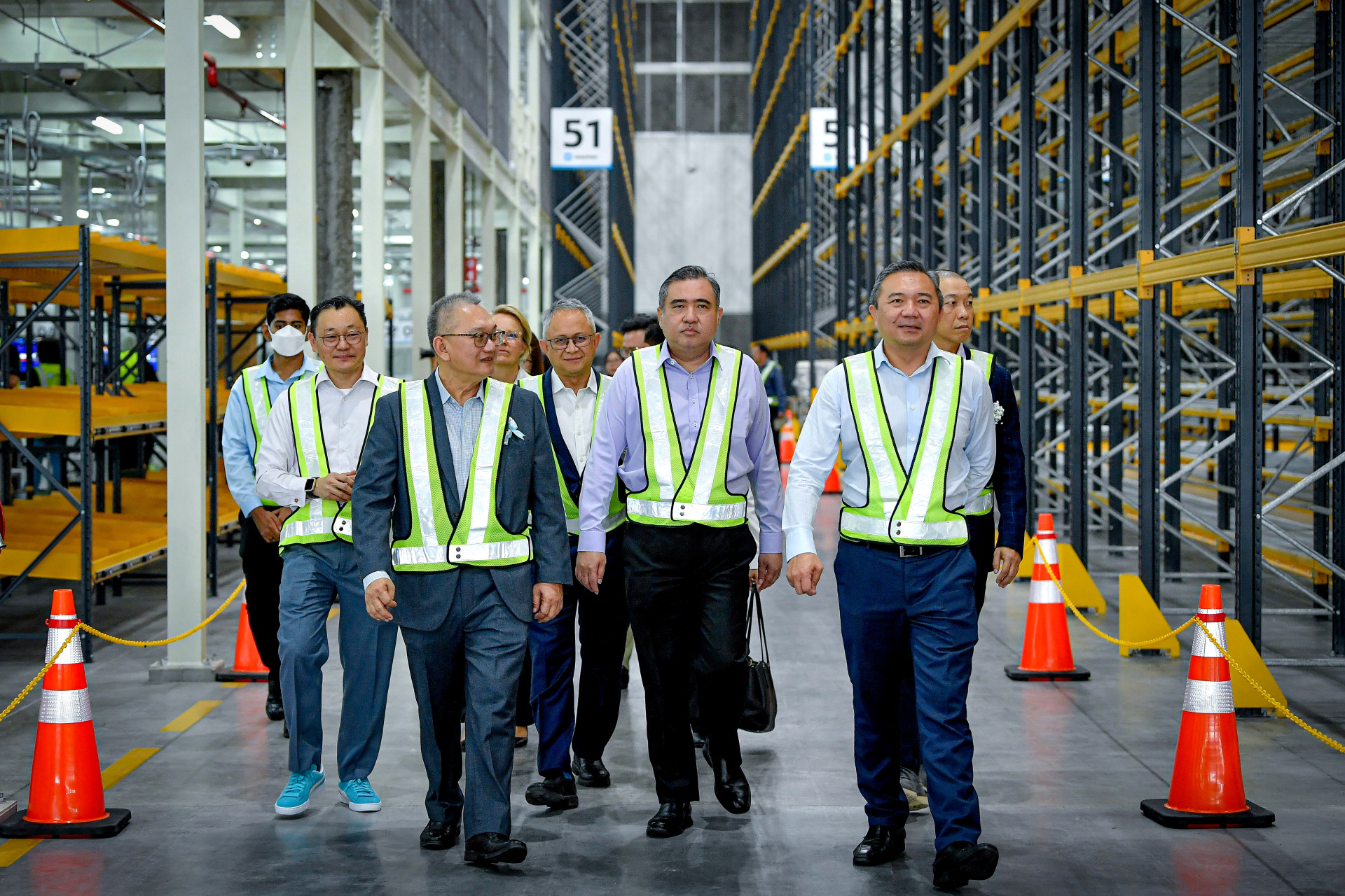 陆兆福（前排中）在黄思汉（前排右）等的陪同下，巡视大马马士基大型配送中心。