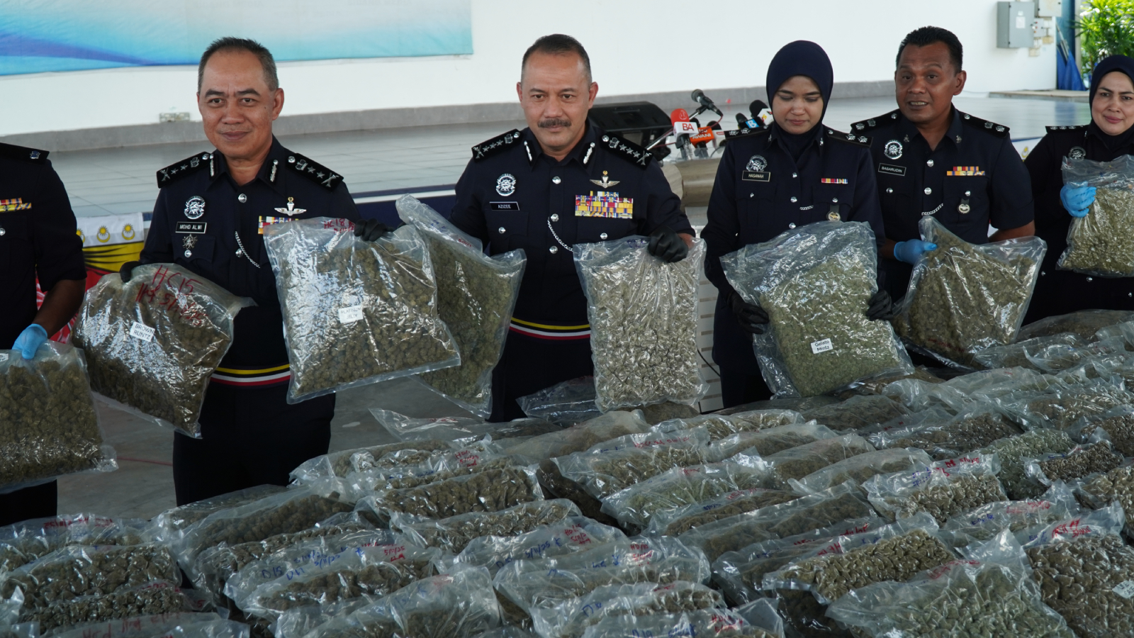 阿兹兹（左2）向记者展示警方在本次行动中的收获，左为槟州副总警长拿督莫哈末阿尔维。