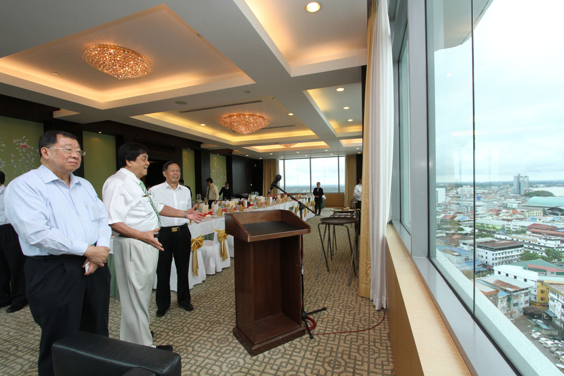 张晓卿在诗巫扎根,并在完成教育后,毅然投身商界创立常青集团,也拓展业务到多个领域,成为大马最具规模跨产业集团之一;图为张晓卿(中)于2017年招待印尼华商菁英张锦雄(左起)和时任世福常务副会长吴换炎,在大窗户前欣赏诗巫的美景。