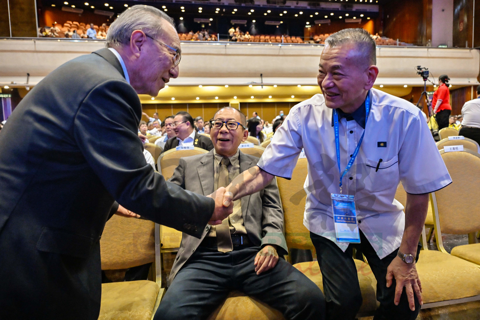 陈德钦（右）与叶炳汉握手问好。中为曹智雄。