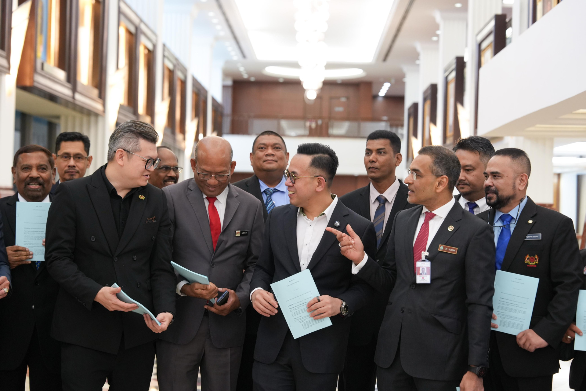 沈志强(右3)为雇员社会安全(修正)法案通过后在议会厅外,和官员及议员轻松交流。