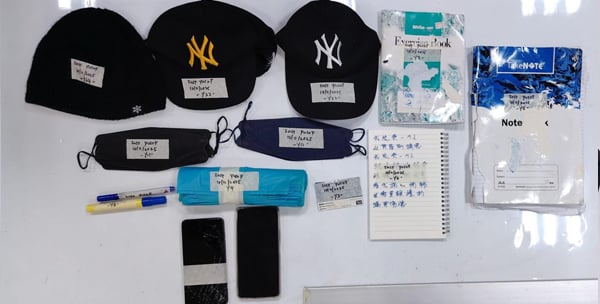 警方起获多个帽子、记录簿、口罩和2台手机。