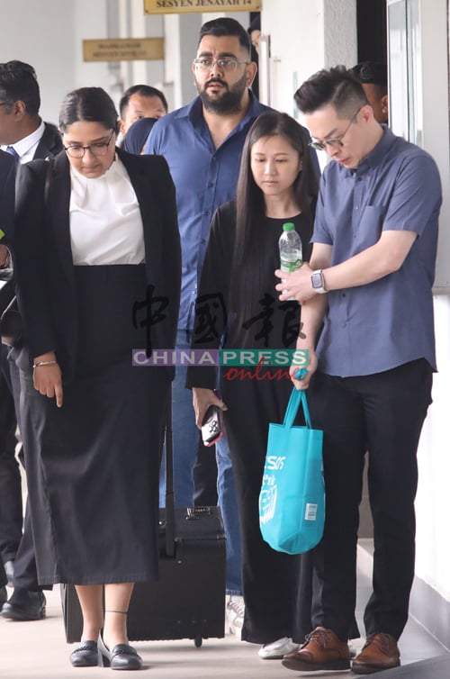 刁健城的妻子李佩丽（译音，右2）陪同丈夫出庭。